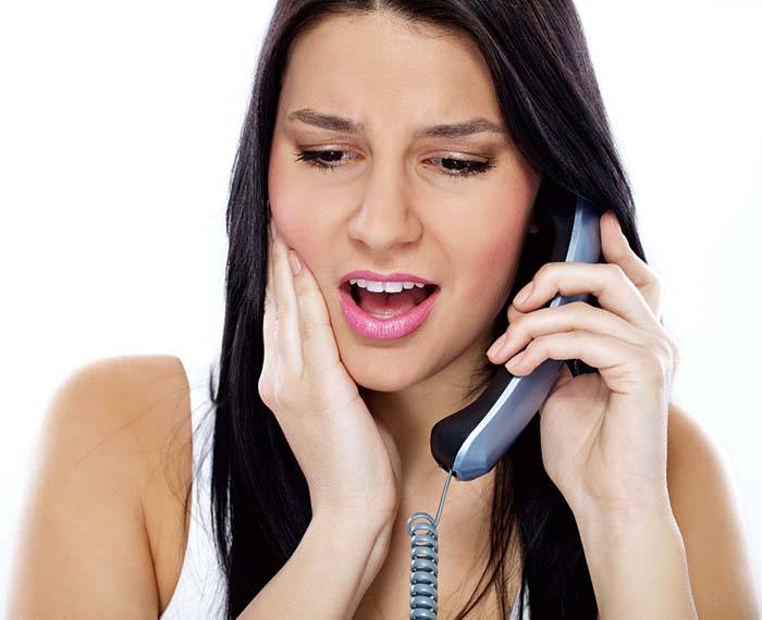 Woman calling her Gilbert emergency dentist for toothache treatment