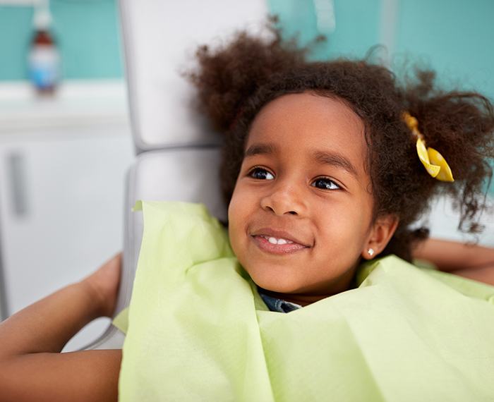 Little girl in dental chair smiling during children's dentistry visit