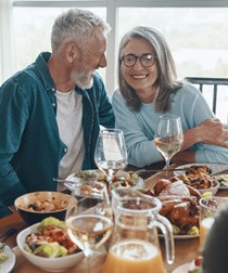 people laughing at dinner table 