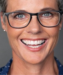 closeup of woman smiling while wearing glasses 