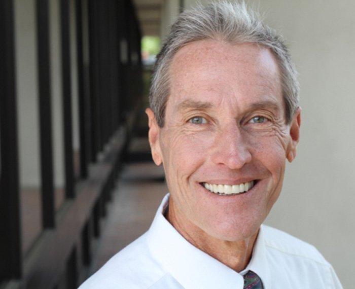 Senior man with tie standing and smiling