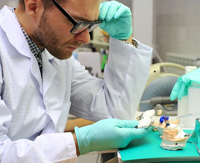 Dental lab technician reviewing dental restoration coloring