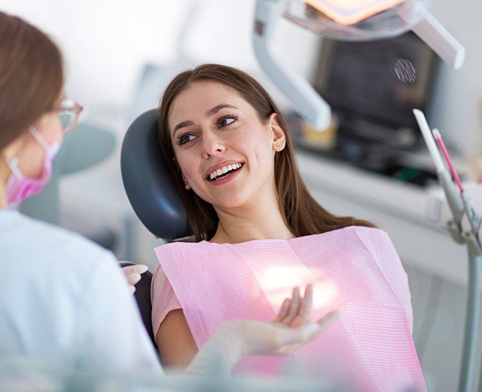 Woman discussing dental insurance coverage with dental team member