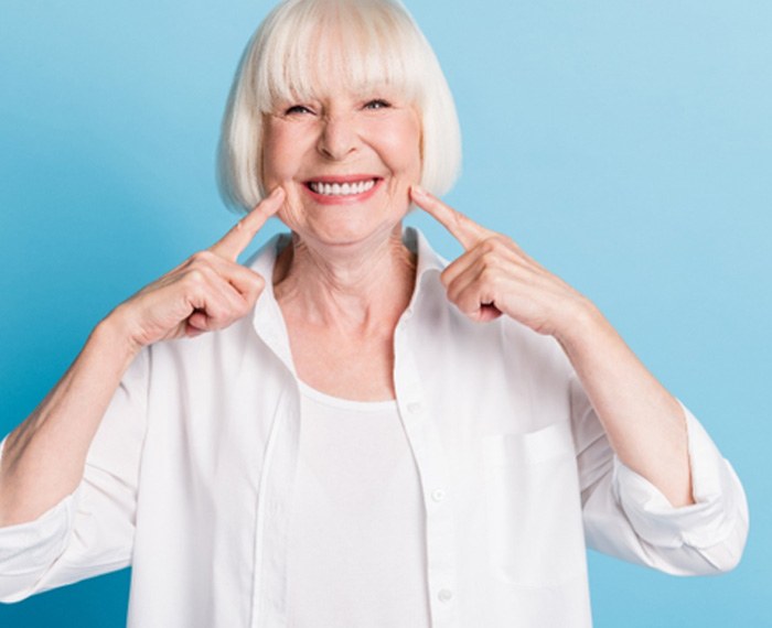 Woman smiling and pointing to teeth