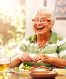 Woman with dentures eating lunch
