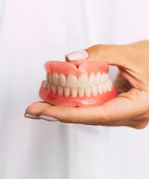 Dentist holding dentures