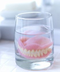 Dentures soaking in a glass