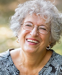 Woman smiling with dentures in Gilbert