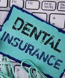 Sign reading “dental insurance” on keyboard