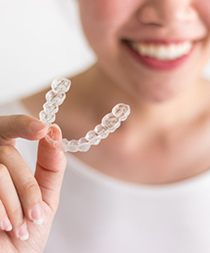 person holding an Invisalign aligner