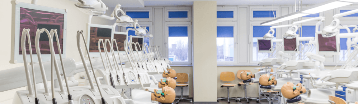 Dental school classroom with mannequin patients in dental chairs