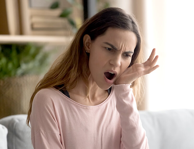 Woman in need of emergency dentistry holding jaw