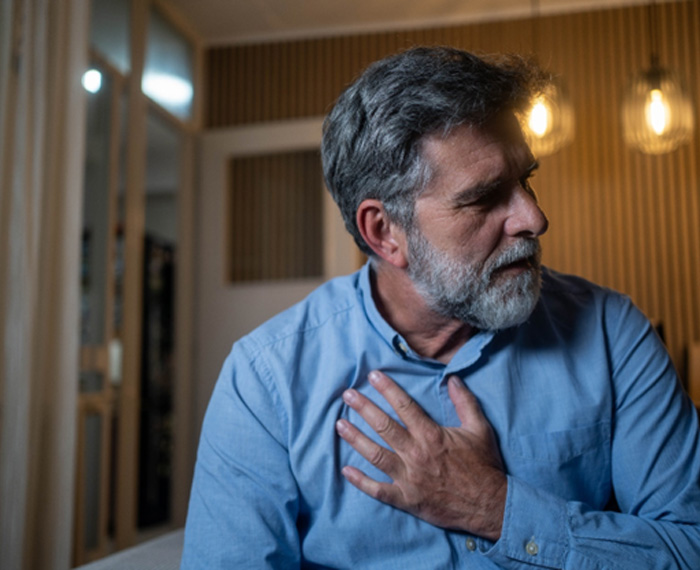 Man touching his chest, concerned about his heart health