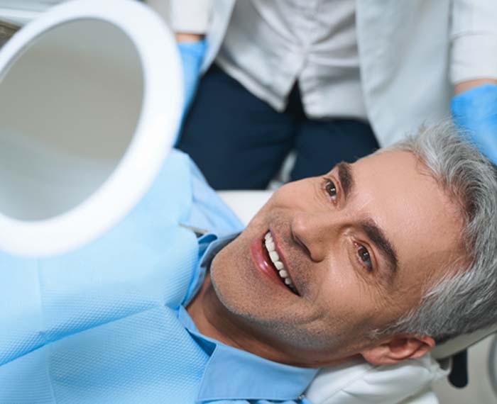 Man admiring his new veneers in Gilbert