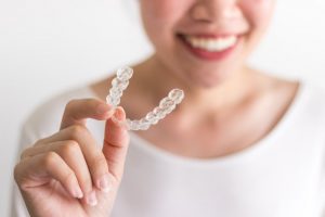 person holding an Invisalign clear aligner 