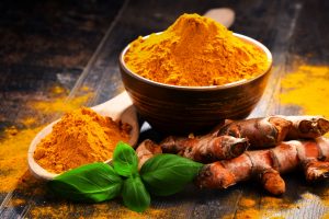 Turmeric leaf, root, and powder on a table