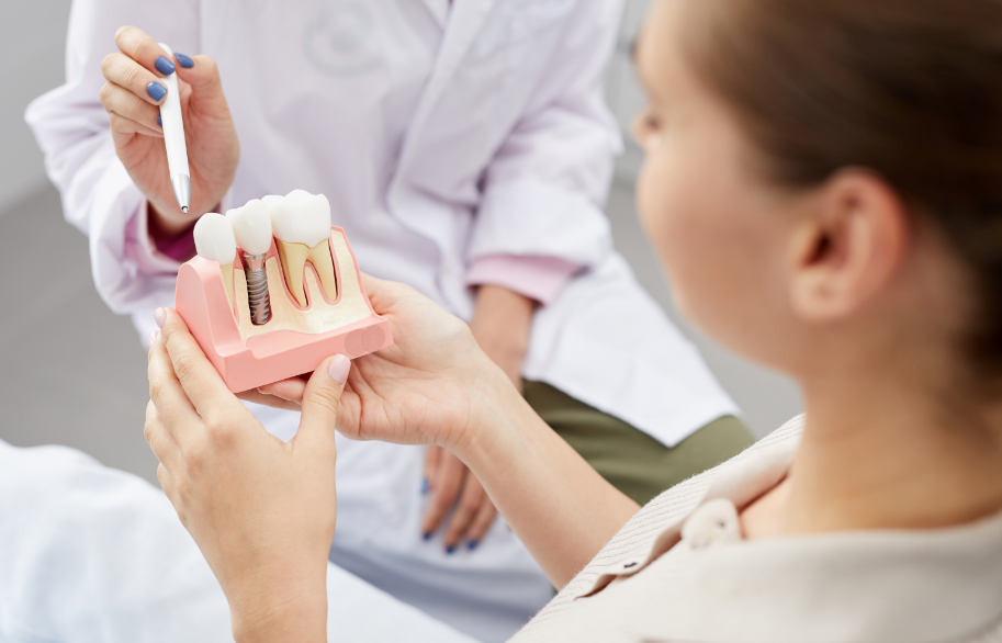 Patient being shown a dental implant model